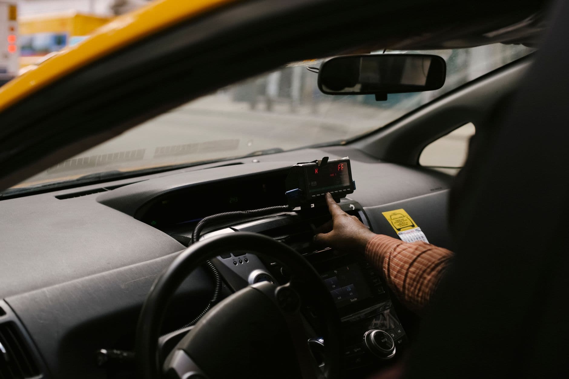 Chauffeur de taxi au volant avec le taximètre